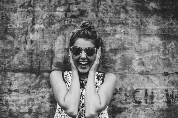 excited woman with hands on side of her head